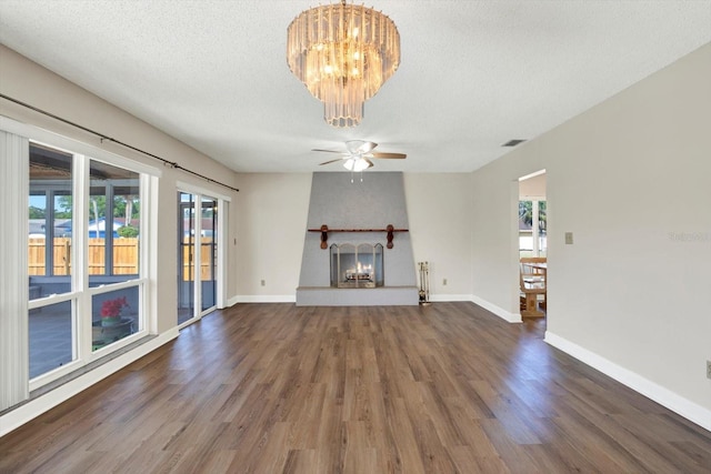 unfurnished living room with visible vents, wood finished floors, baseboards, a textured ceiling, and a large fireplace