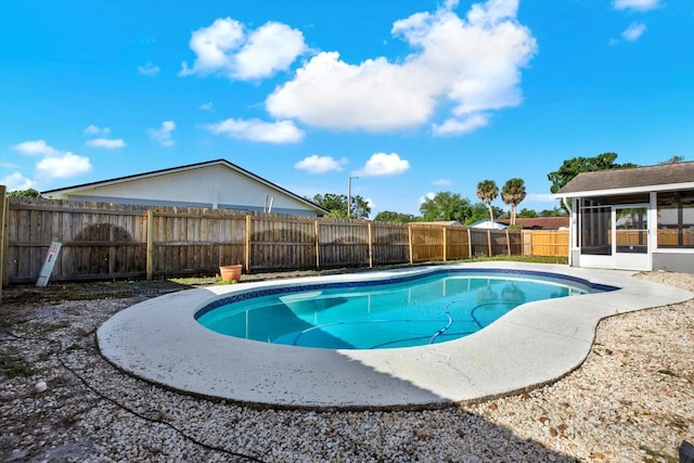 view of swimming pool featuring a fenced in pool, a fenced backyard, and a sunroom