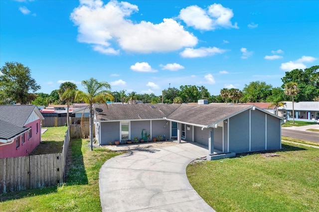 single story home featuring concrete driveway, fence, roof with shingles, and a front lawn