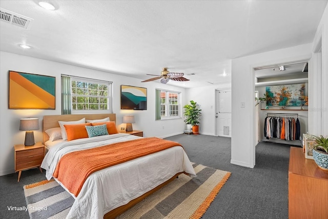 bedroom with baseboards, multiple windows, dark colored carpet, and visible vents