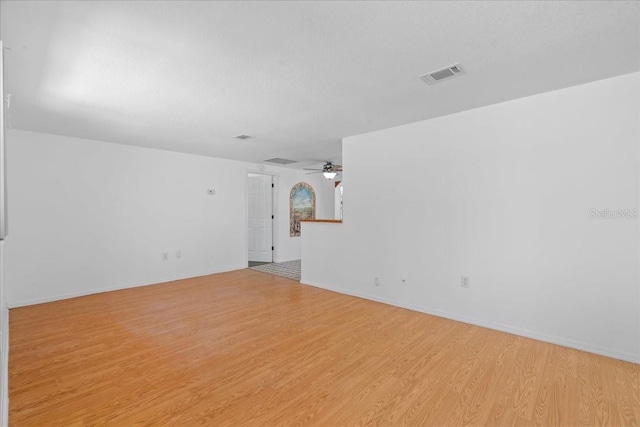 unfurnished room with a ceiling fan, baseboards, visible vents, and light wood finished floors
