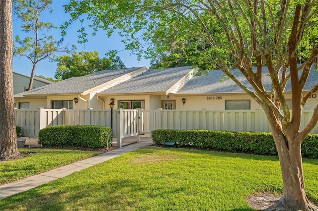 view of front of property with a gate, a fenced front yard, stucco siding, and a front lawn