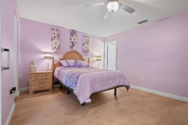 bedroom featuring a ceiling fan, baseboards, visible vents, and light wood-type flooring