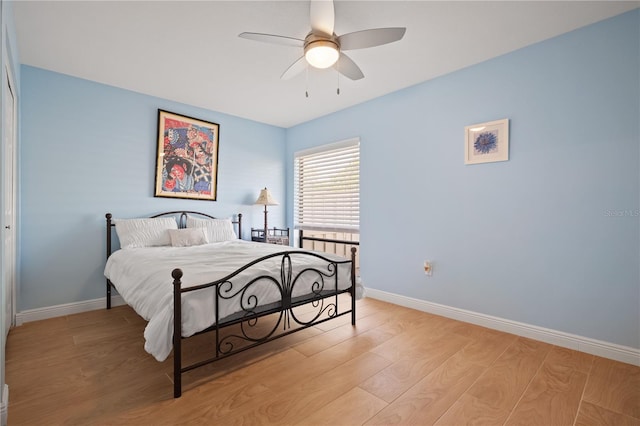 bedroom with baseboards, a ceiling fan, and light wood finished floors