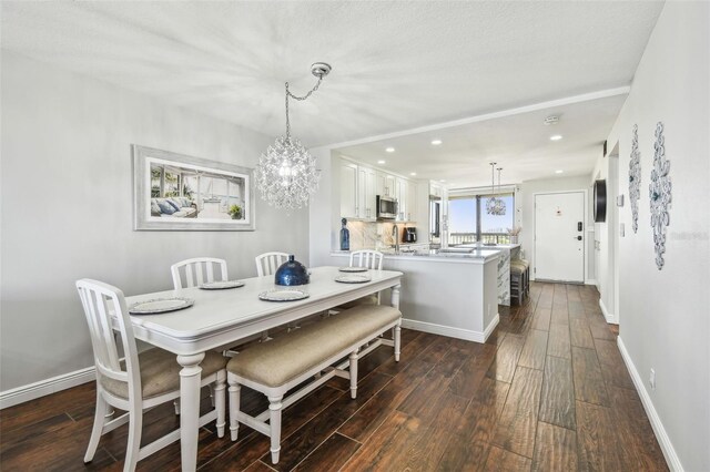 dining room with an inviting chandelier, recessed lighting, dark wood-style flooring, and baseboards