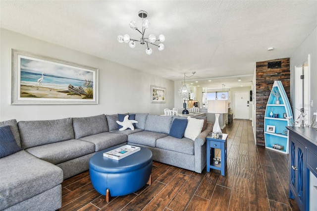 living room with an inviting chandelier, a textured ceiling, and dark wood-type flooring