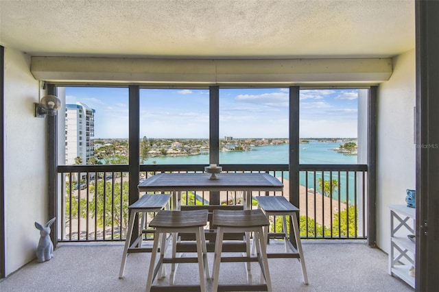sunroom featuring a water view