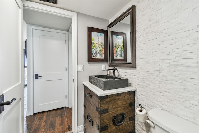 bathroom with vanity, wood finished floors, and toilet