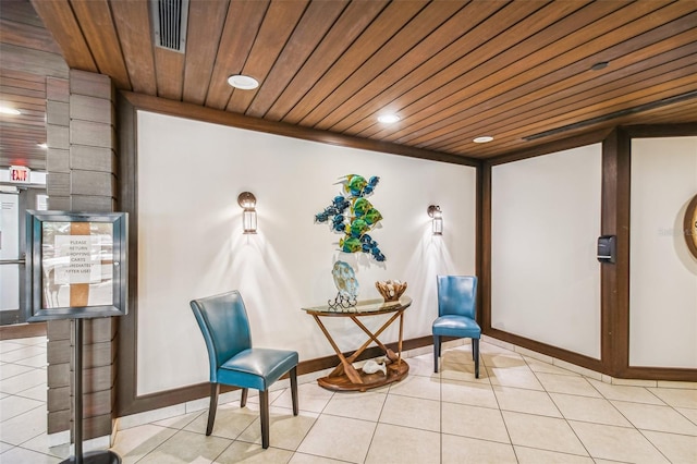 sitting room with wood ceiling, tile patterned floors, and visible vents
