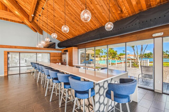 kitchen featuring wood ceiling, beam ceiling, light countertops, high vaulted ceiling, and built in refrigerator