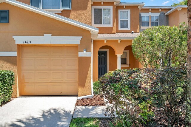 view of front of house with concrete driveway, a garage, and stucco siding
