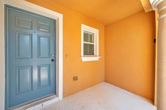 doorway to property featuring stucco siding