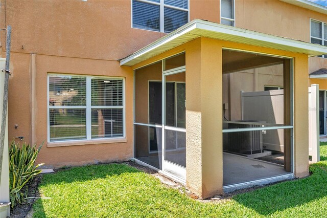 view of property exterior featuring central AC unit, stucco siding, and a sunroom