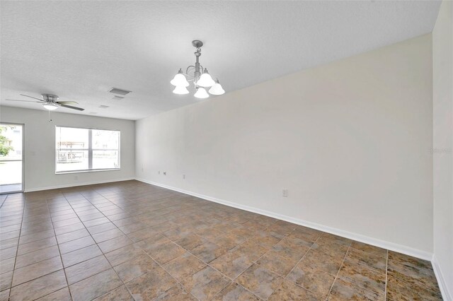 unfurnished room featuring baseboards, ceiling fan with notable chandelier, and a textured ceiling