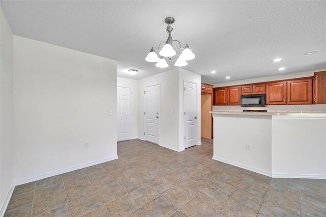kitchen featuring an inviting chandelier, black microwave, baseboards, recessed lighting, and decorative light fixtures