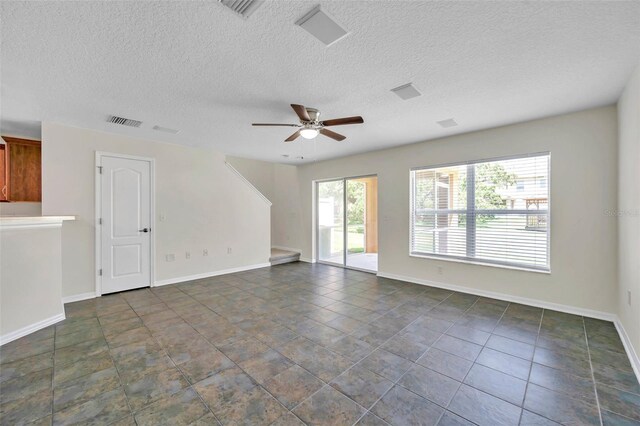unfurnished living room with visible vents, a textured ceiling, ceiling fan, and baseboards