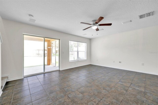 spare room with visible vents, a textured ceiling, ceiling fan, and baseboards