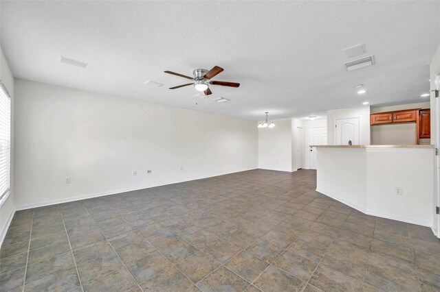 unfurnished living room featuring visible vents, a healthy amount of sunlight, baseboards, recessed lighting, and ceiling fan with notable chandelier