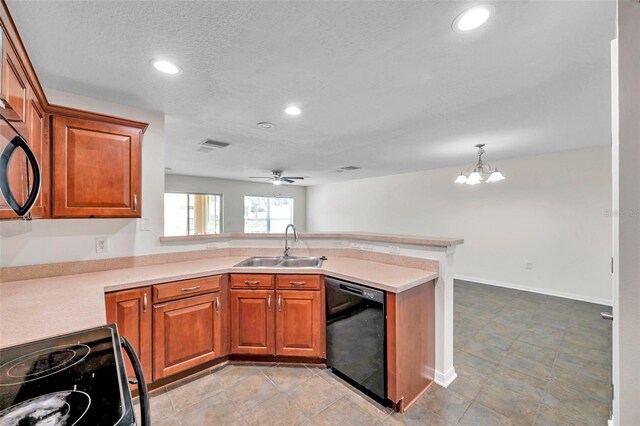 kitchen with a peninsula, light countertops, brown cabinets, a sink, and black appliances