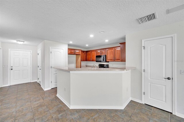 kitchen with light countertops, baseboards, black microwave, and visible vents