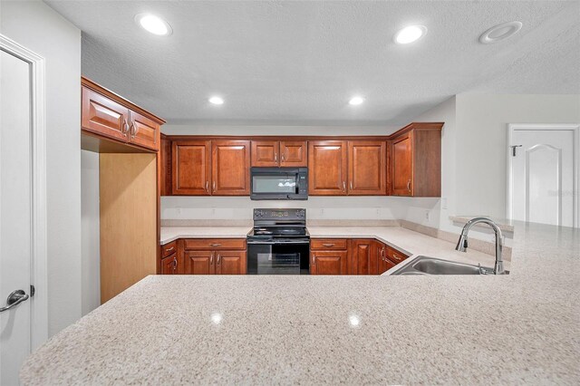 kitchen with light countertops, recessed lighting, a sink, and black appliances