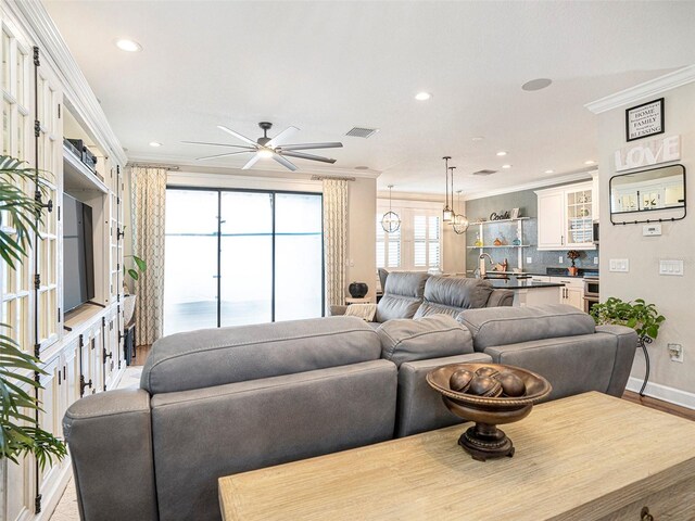 living area with crown molding, ceiling fan, recessed lighting, and visible vents