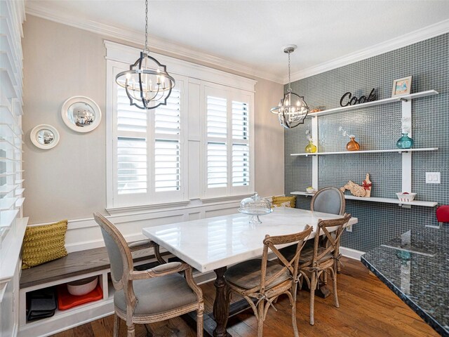 dining room with crown molding, wood finished floors, and a chandelier