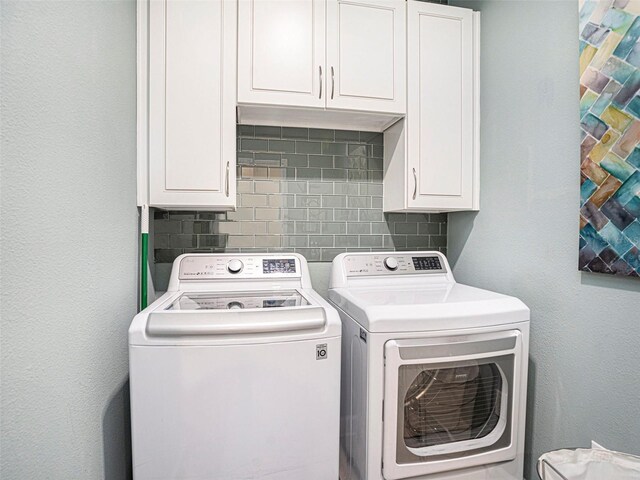 laundry area with cabinet space and washing machine and clothes dryer