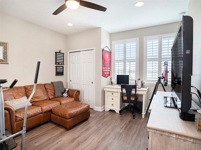 office space featuring baseboards, a ceiling fan, recessed lighting, and light wood-style flooring