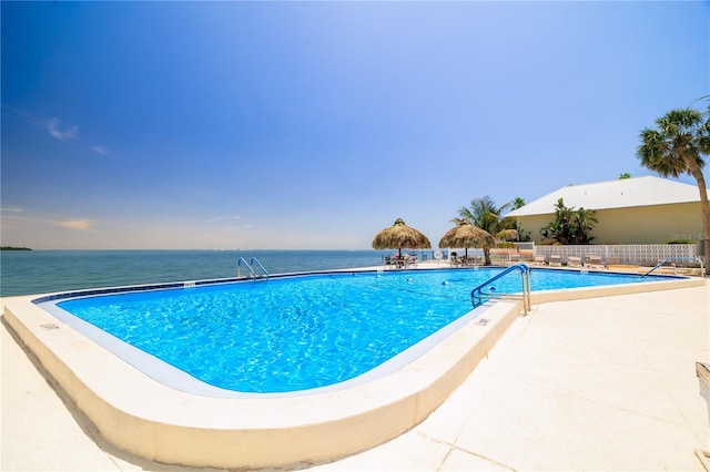 pool with a water view and a patio area