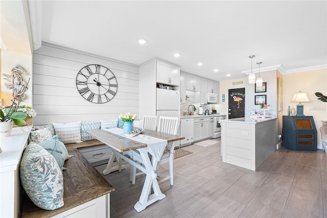 kitchen featuring recessed lighting, backsplash, white appliances, and a sink