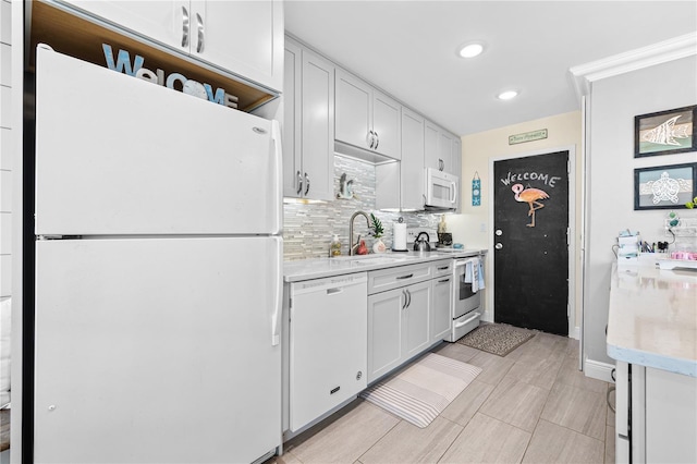 kitchen with white appliances, recessed lighting, decorative backsplash, and light countertops