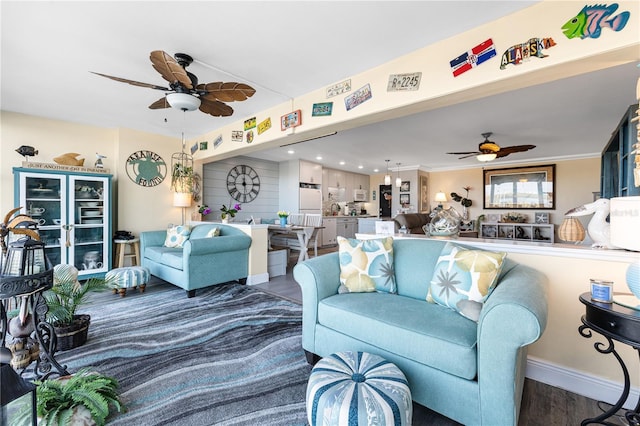 living area with baseboards, ceiling fan, and wood finished floors