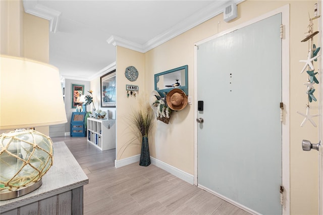 foyer featuring crown molding, baseboards, and light wood-style flooring