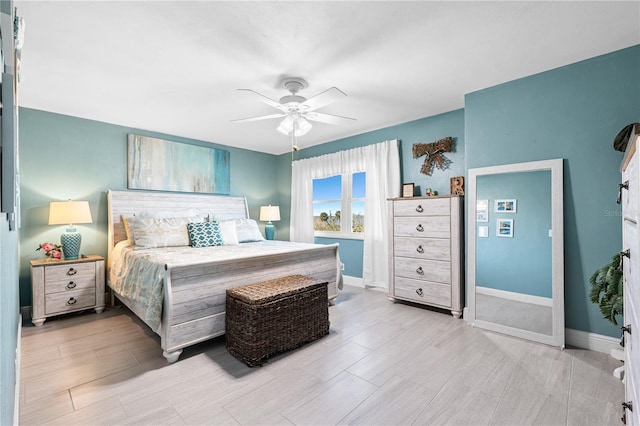 bedroom with baseboards, light wood finished floors, and ceiling fan