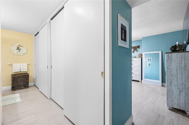 hallway with light wood-style floors and baseboards