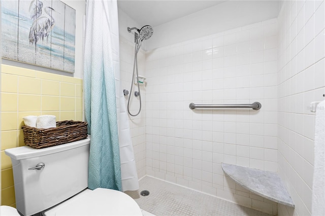 full bath featuring toilet, tile walls, and tiled shower