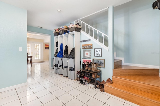 stairs with tile patterned floors, visible vents, and baseboards