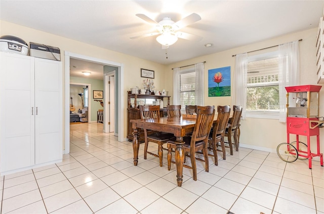 dining room with a ceiling fan, baseboards, and light tile patterned floors