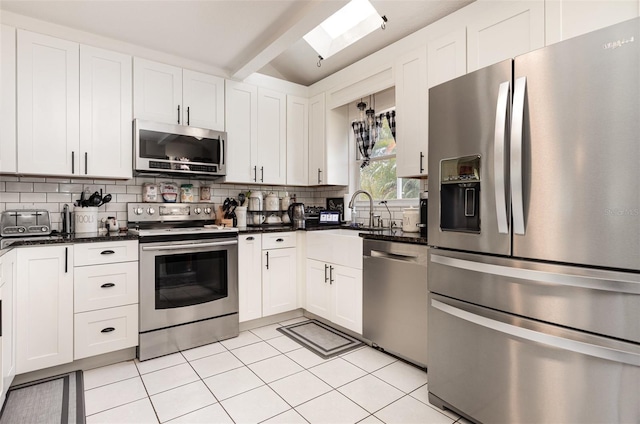 kitchen with white cabinetry, decorative backsplash, stainless steel appliances, and a sink