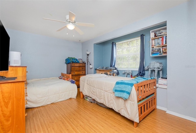 bedroom featuring ceiling fan, baseboards, and light wood-style floors