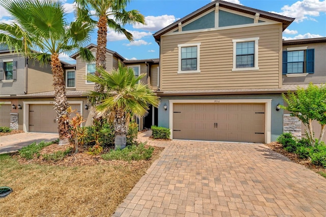 view of front facade with an attached garage, decorative driveway, and stucco siding