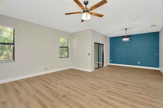 empty room with ceiling fan, visible vents, baseboards, and light wood-type flooring