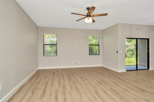 spare room featuring baseboards, a ceiling fan, and light wood-style flooring