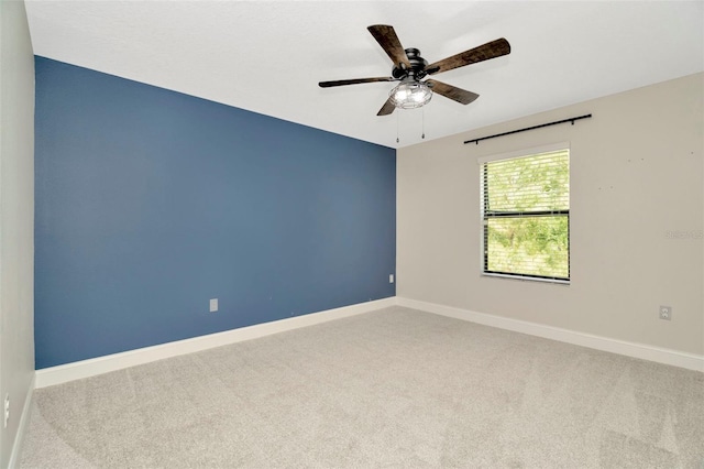 empty room featuring baseboards, carpet flooring, and ceiling fan