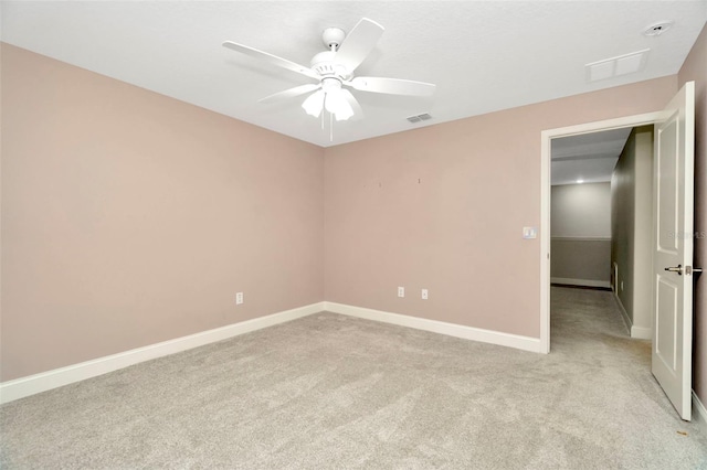 spare room with light carpet, a ceiling fan, and visible vents