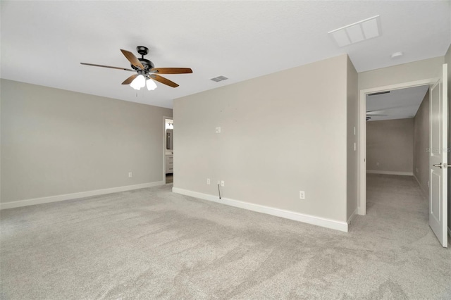 spare room featuring ceiling fan, visible vents, light carpet, and baseboards