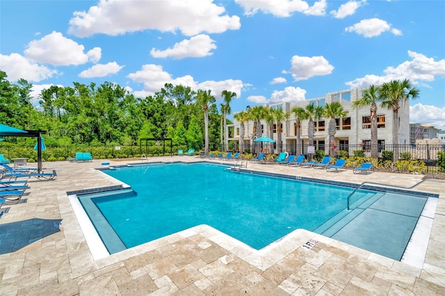 pool with a patio and fence