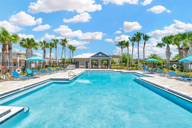 community pool with fence and a patio area