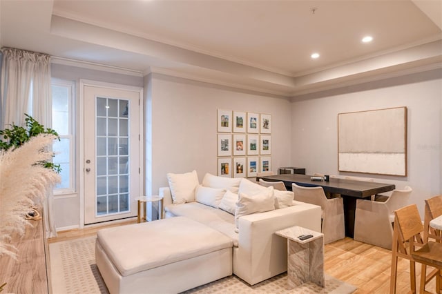 interior space featuring recessed lighting, ornamental molding, light wood-style flooring, and a raised ceiling
